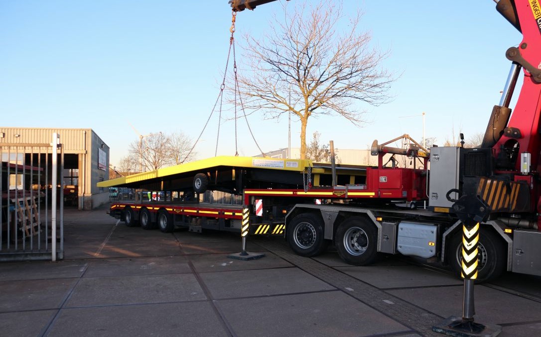 Laadbrug van 20 ton wordt met een kraan op een vrachtwagen gezet